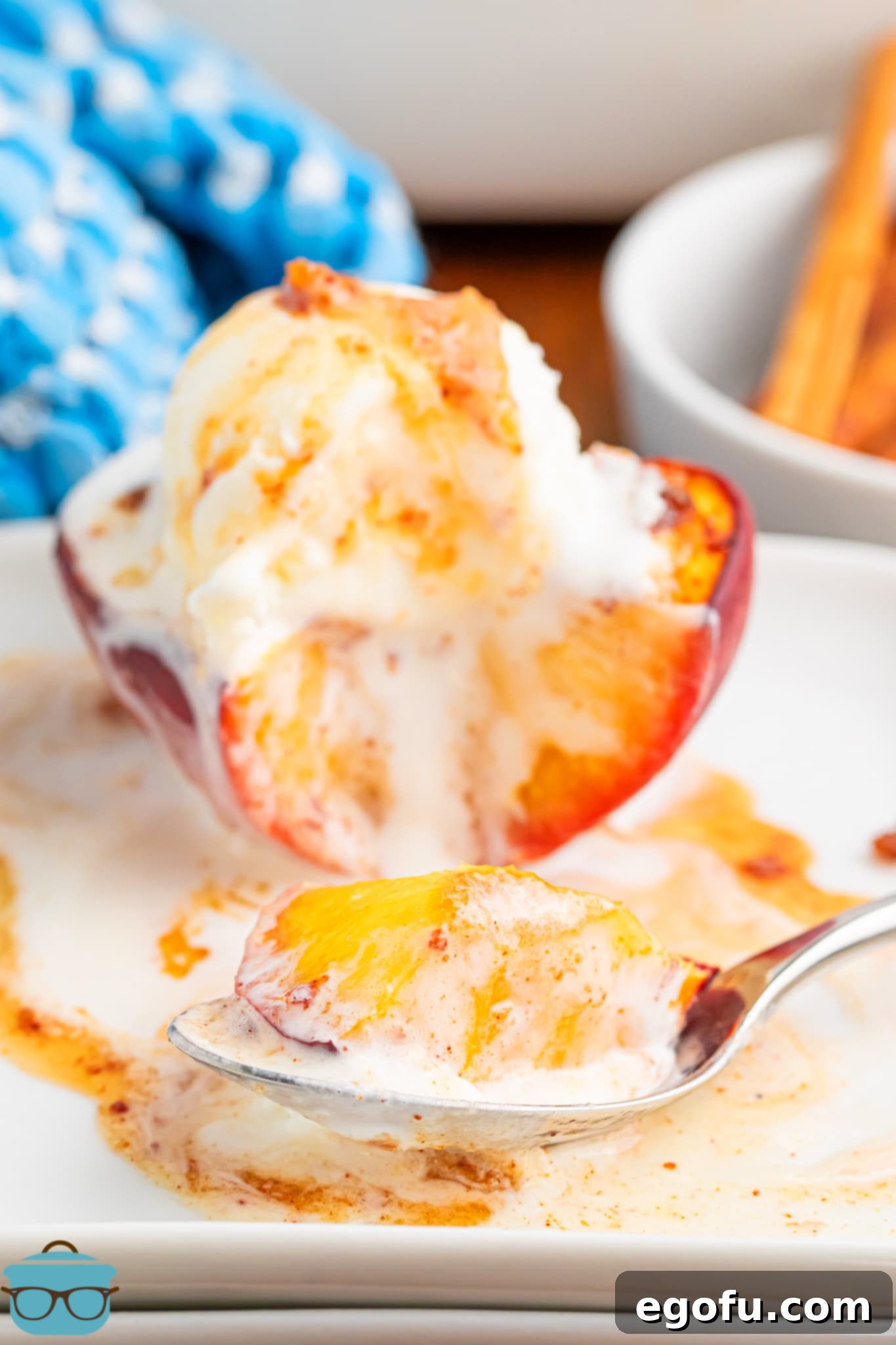 A beautifully plated Baked Peach half, topped with a scoop of vanilla ice cream and a garnish, ready to be enjoyed.