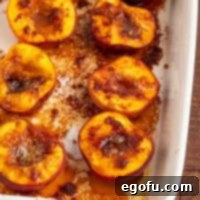 A close-up of a dish of perfectly baked peaches, golden and glistening.