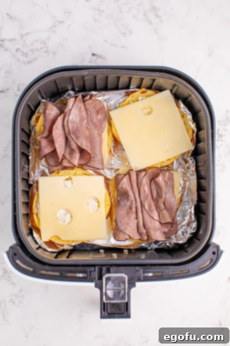 Ultimate Air Fryer Roast Beef Melts 11 Roast beef and cheese on buns in a basket.