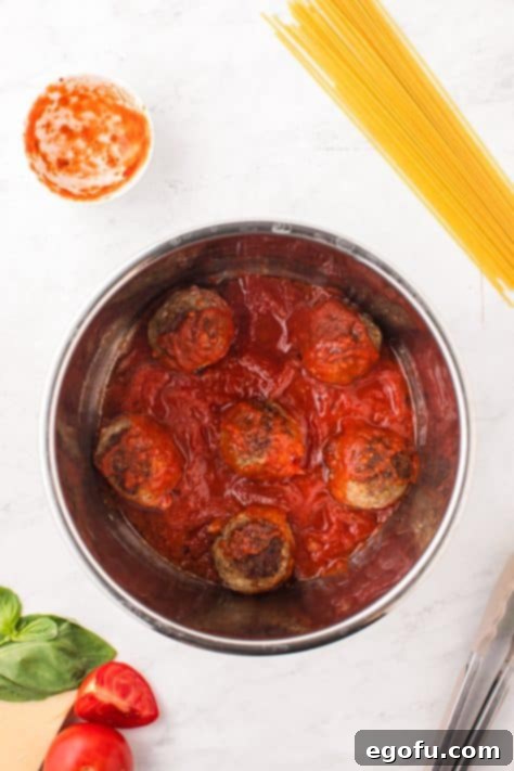 Meatballs nestled in rich marinara sauce inside the Instant Pot, ready for pressure cooking.
