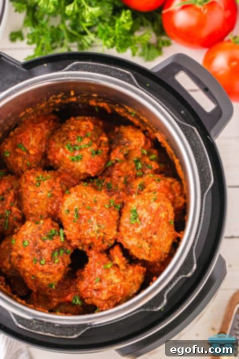 The finished homemade meatballs, perfectly cooked and glistening in marinara sauce, visible inside the Instant Pot after pressure release.