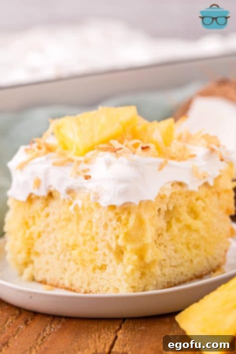 Sun-Kissed Hawaiian Poke Cake 18 A piece of Hawaiian Poke Cake on a dessert plate.