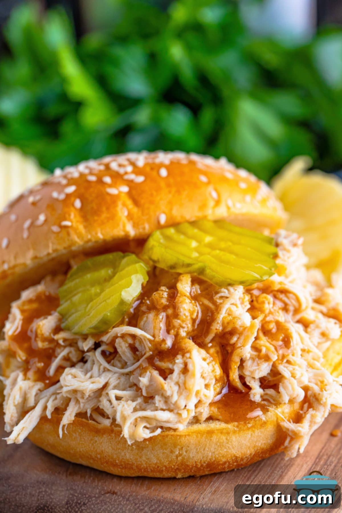 Close up looking at some Crock Pot Shredded Nashville Hot Chicken on a roll.