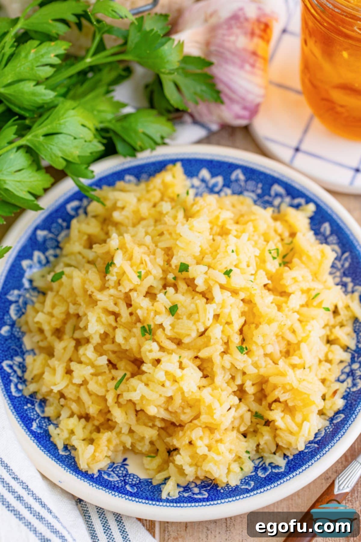A large plate of Garlic Butter Rice, garnished with fresh herbs, showcasing its rich texture and inviting aroma.