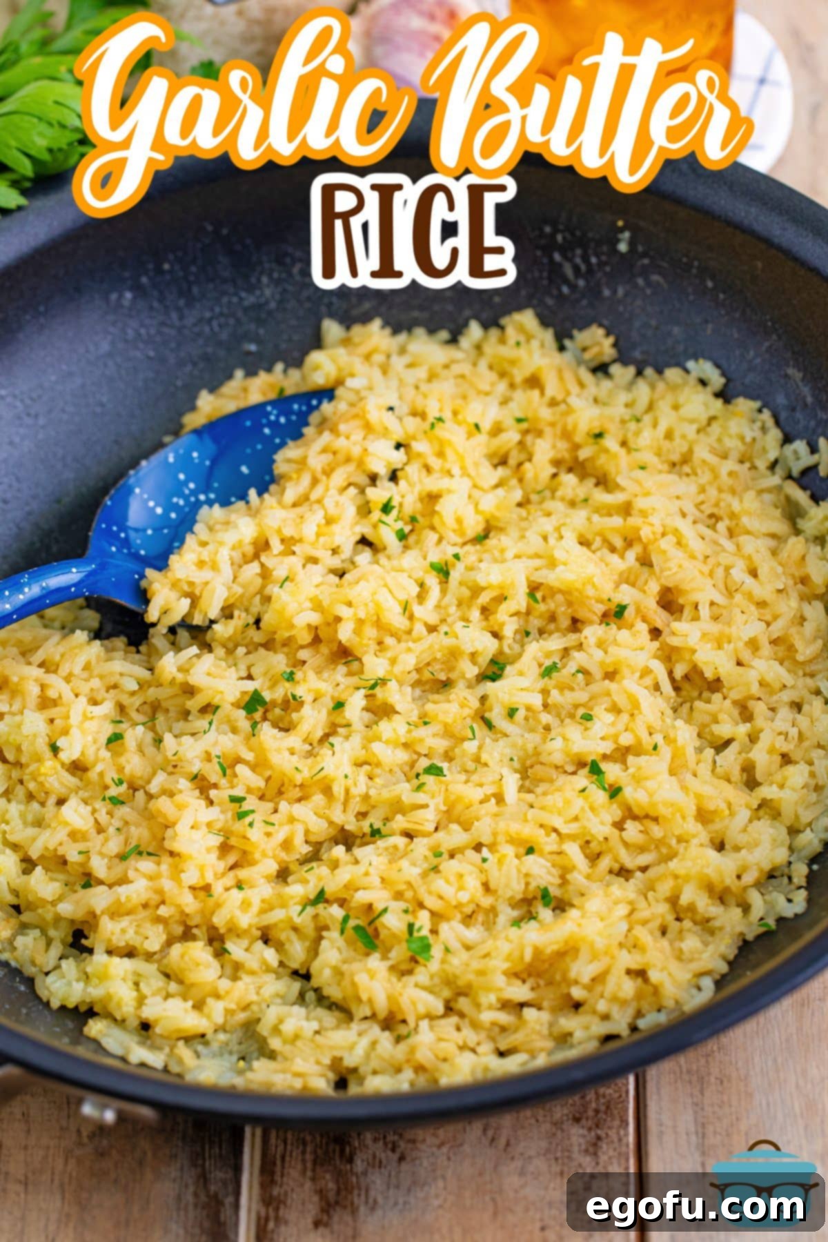 A close-up shot of Garlic Butter Rice in a skillet, with a blue spatula gently stirring it, highlighting the fluffy texture and aromatic garlic bits.