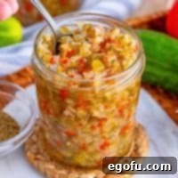 Close up looking at a jar of Homemade Sweet Pickle Relish with a spoon in it.