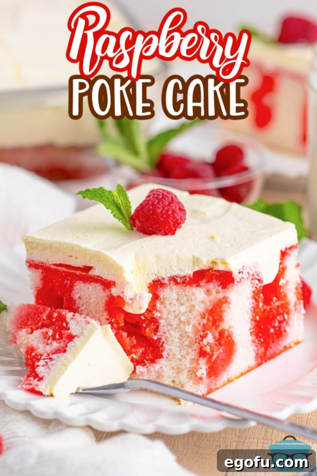 The full Raspberry Poke Cake, glistening with creamy frosting and ready to be cut.