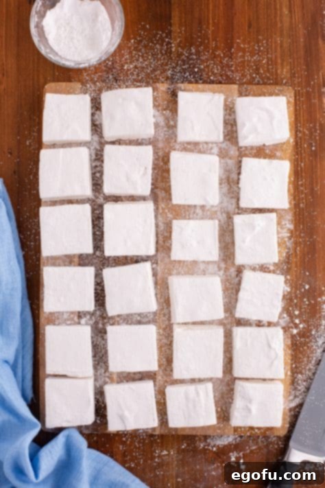 A bunch of cut, Homemade Marshmallows on a board.