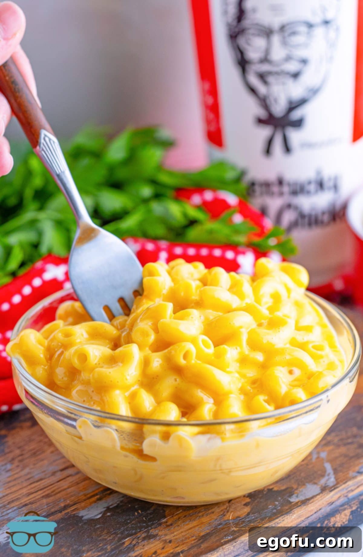 A fork in a bowl of homemade KFC Mac and Cheese, showcasing its creamy texture.