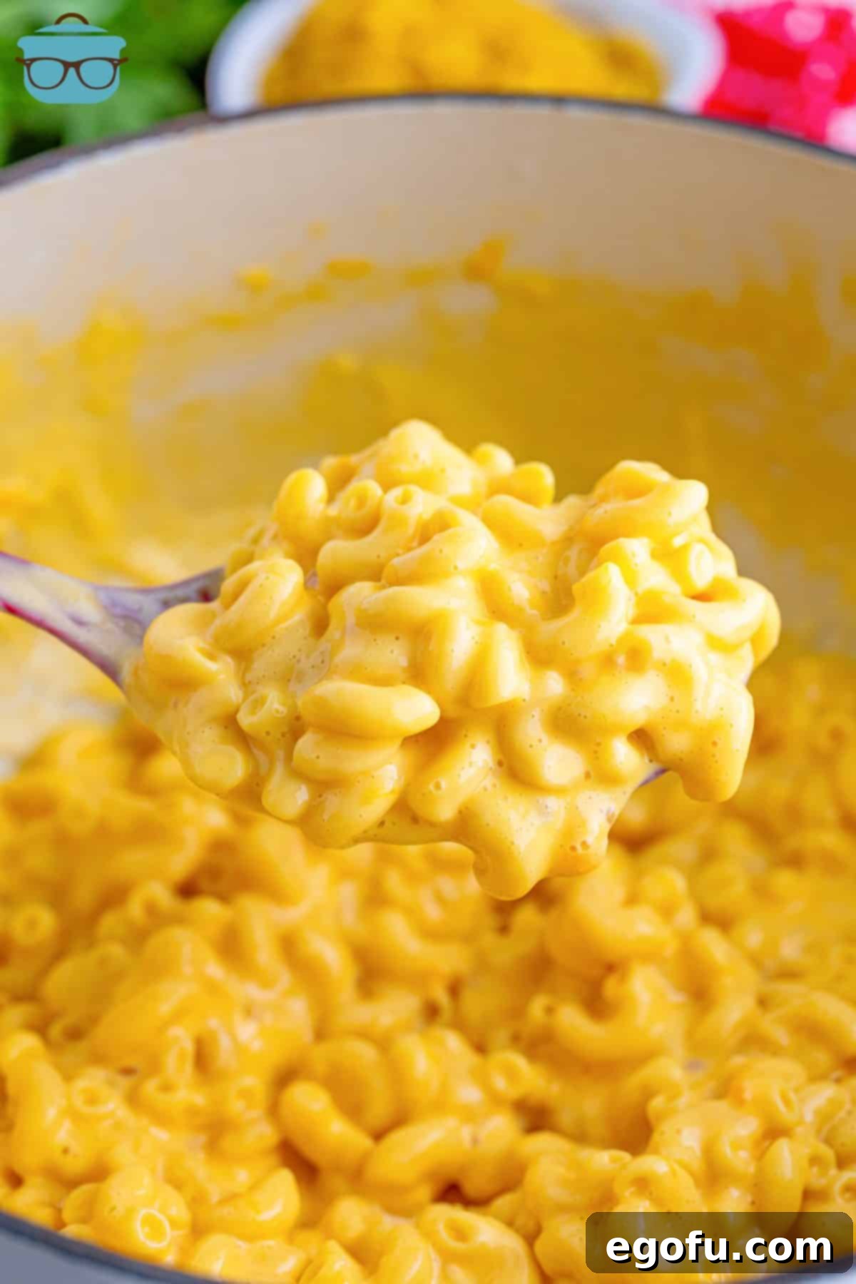 A generous scoop of creamy, homemade KFC Mac and Cheese being lifted from the pot, showcasing its perfect consistency.