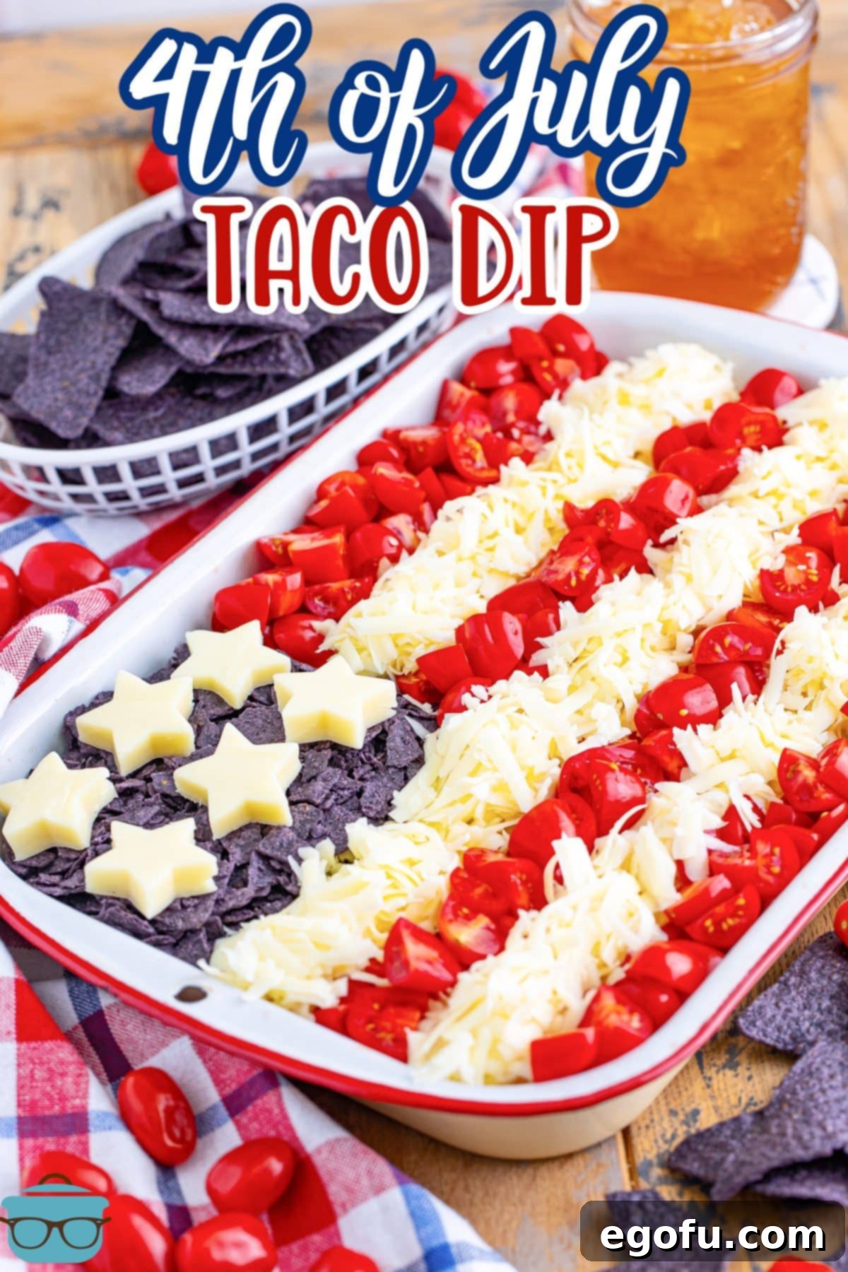 Stars and Stripes Celebration Dip 3 A vibrant American Flag Taco Dip, artfully arranged with red tomatoes, white cheese, and blue tortilla chips, ready for serving.