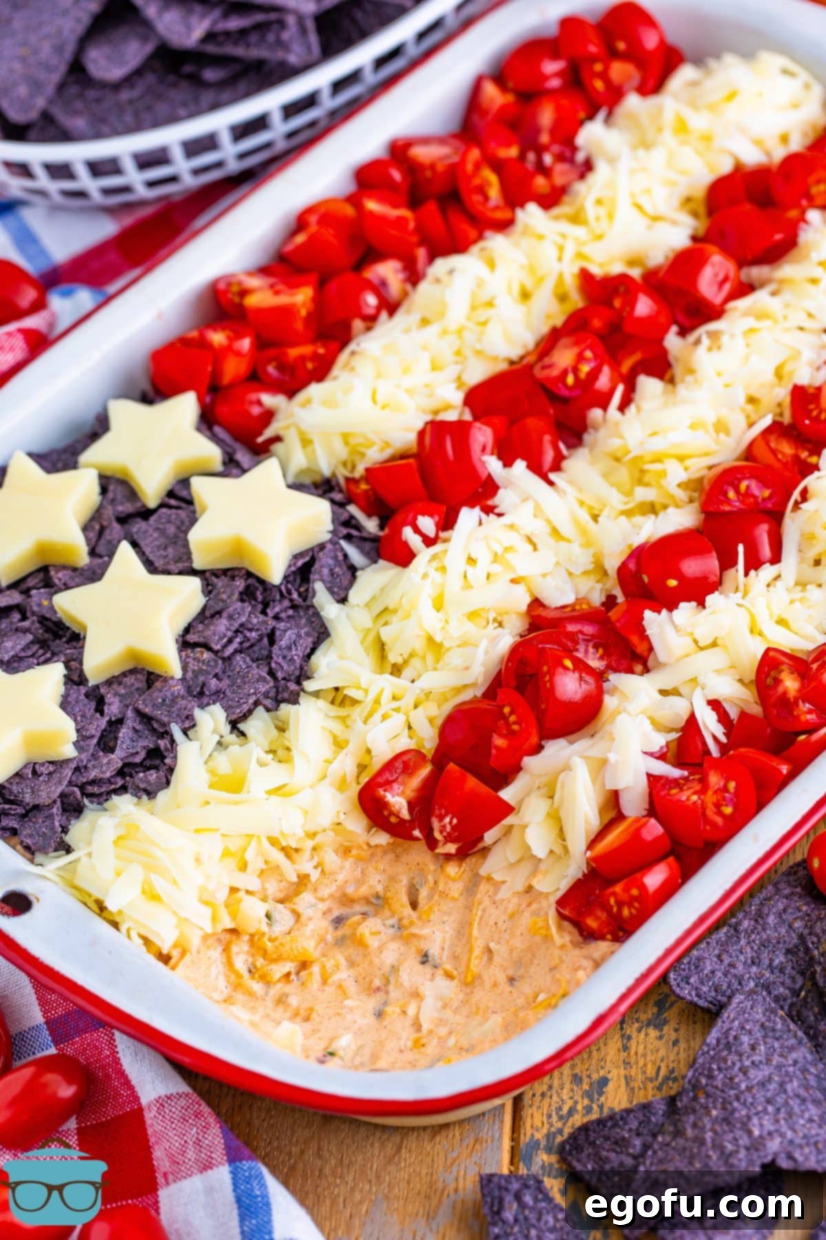 Stars and Stripes Celebration Dip 10 A festive 4th of July Flag Dip in a baking dish with a portion already scooped out, inviting guests to enjoy.