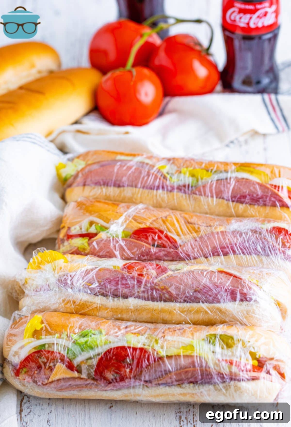 A few homemade copycat Kmart Subs, tightly wrapped in plastic, lying in a neat line, ready for a nostalgic lunch.