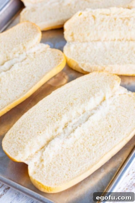 open sub roll buns on a tray.