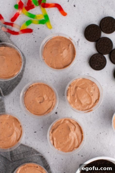 Chocolate pudding and whipped cream in a plastic cup.