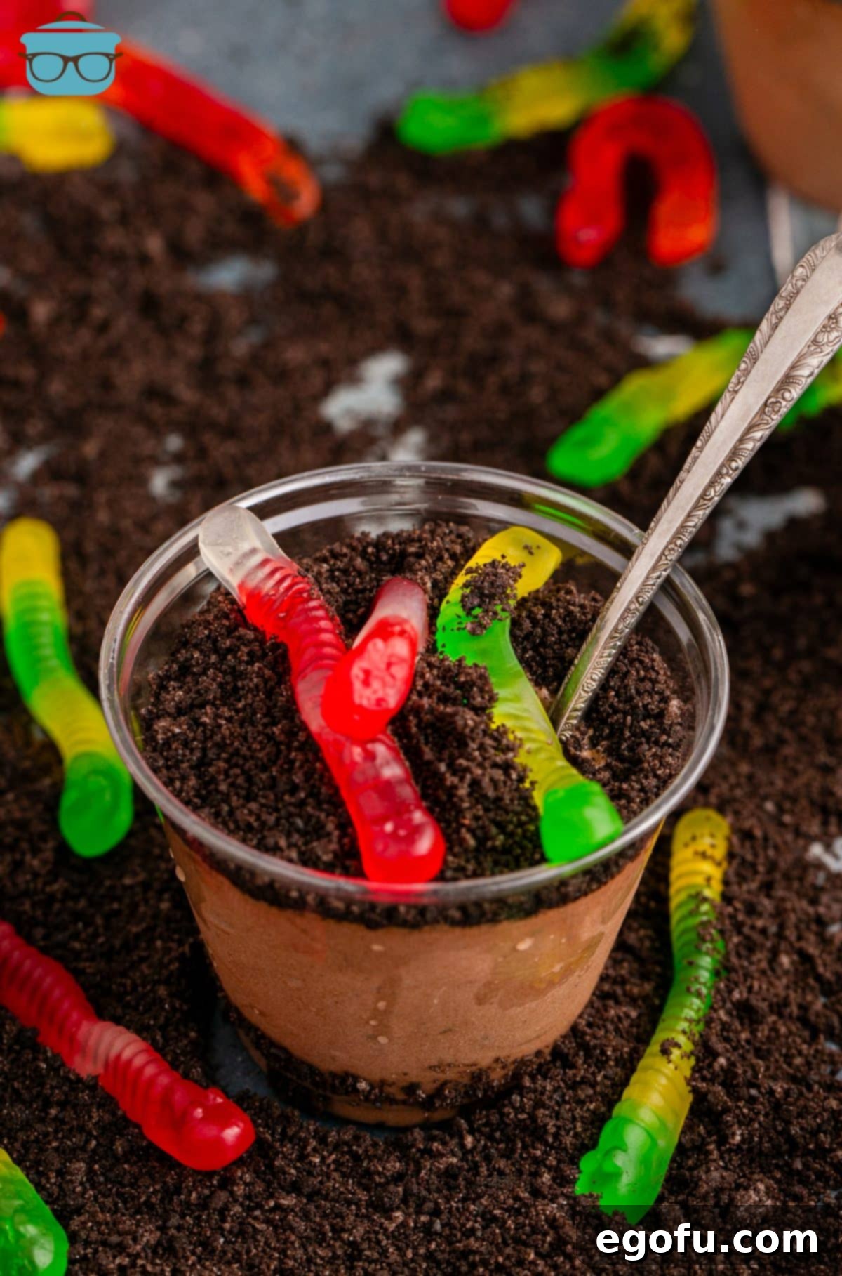 Looking down on a Dirt Cup with gummy worms and a spoon in it.