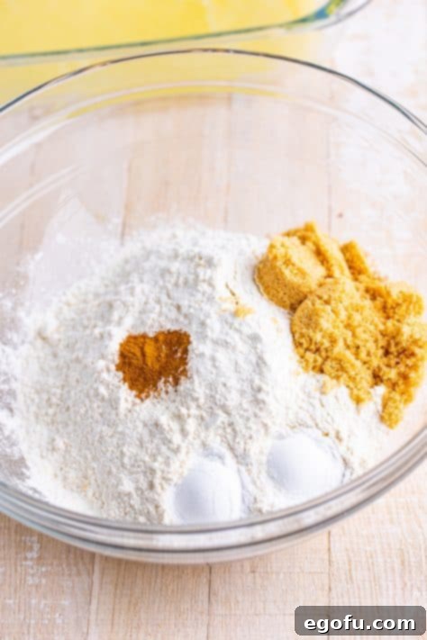 Golden Butter Soaked Cinnamon Sugar Biscuits 11 A mixing bowl with flour, brown sugar, baking powder, and ground cinnamon.