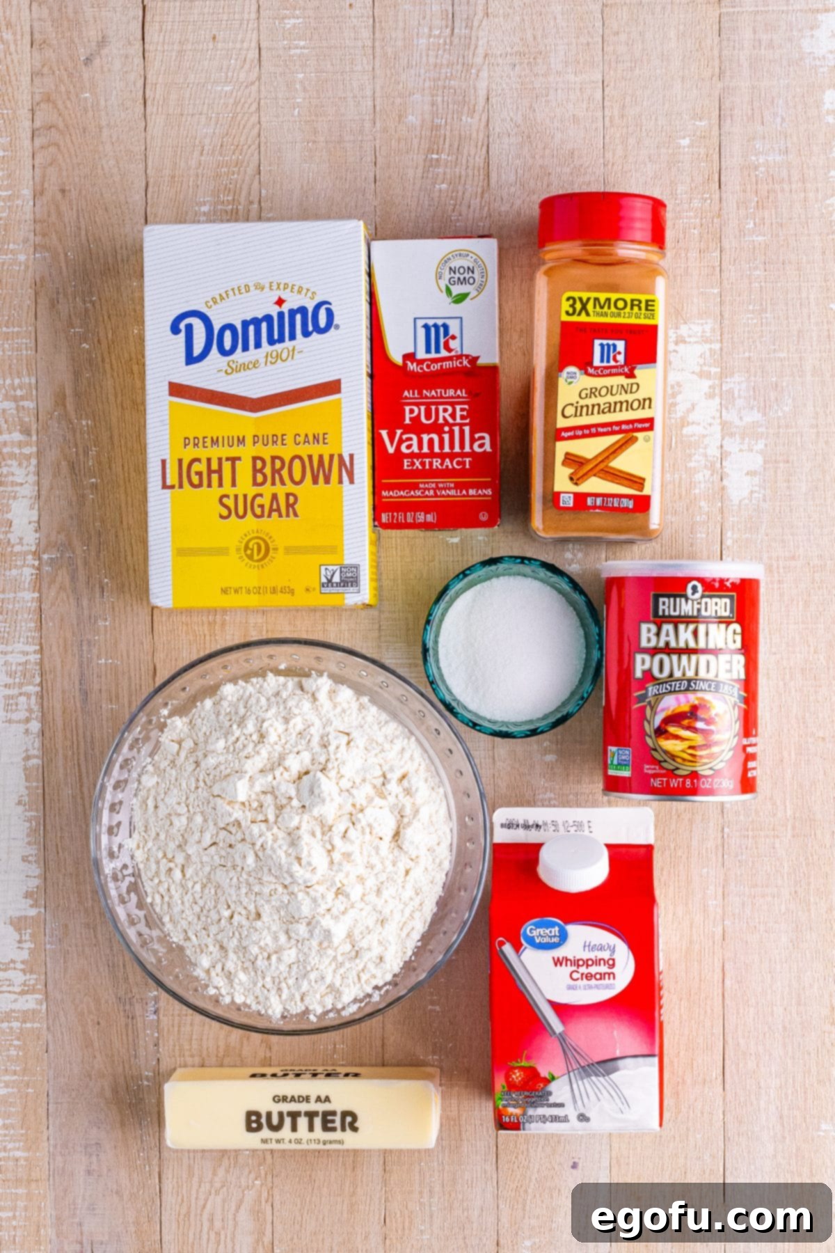 Golden Butter Soaked Cinnamon Sugar Biscuits 4 A flat lay of ingredients for Cinnamon Sugar Butter Swim Biscuits: aluminum-free baking powder, butter, ground cinnamon, granulated sugar, light brown sugar, all-purpose flour, and vanilla extract.