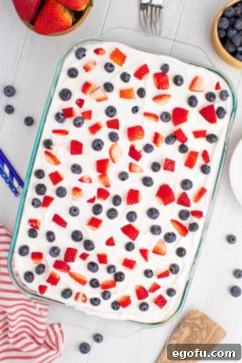 Fresh blueberries and diced strawberries artfully arranged on top of the whipped cream layer of a Patriotic Cake.