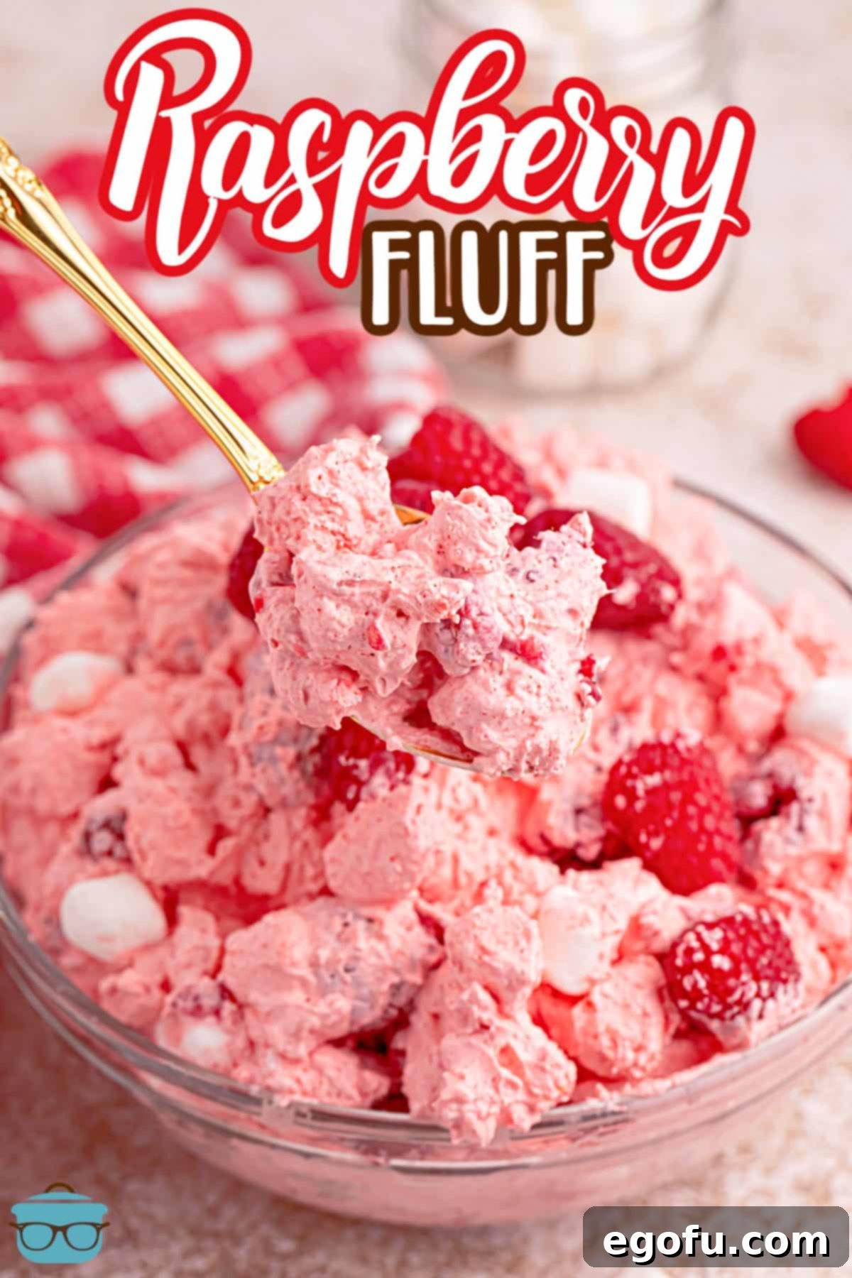 A close-up shot of Raspberry Fluff in a bowl with a spoon, highlighting its creamy texture and fresh raspberries.