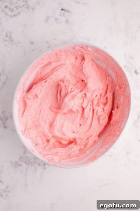 A bowl of raspberry Jell-o, whipped topping and powdered sugar.