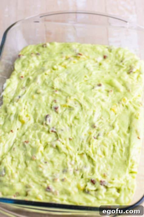 pistachio cake batter spread into a baking dish.
