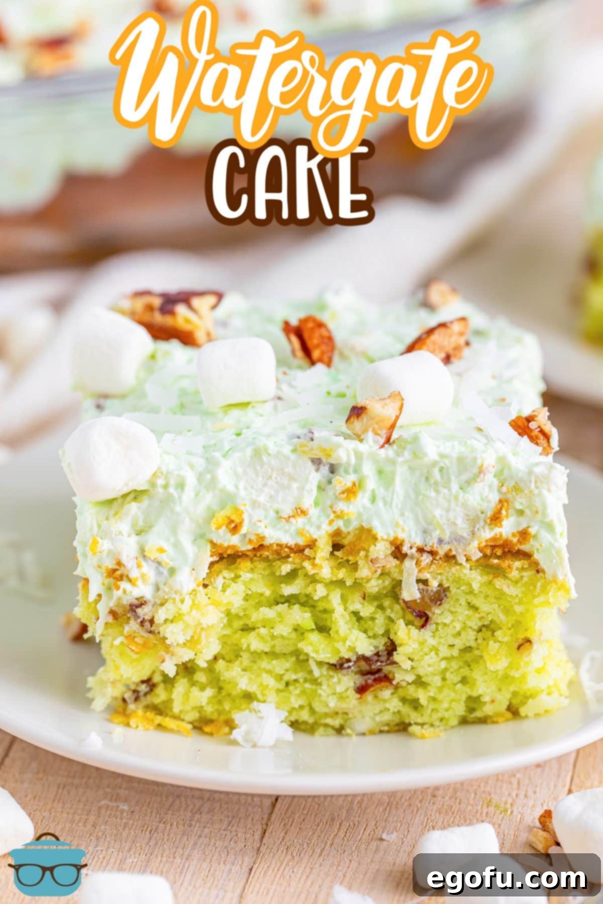 A serving of Watergate Cake topped with mini marshmallows, coconut flakes, and chopped pecans.