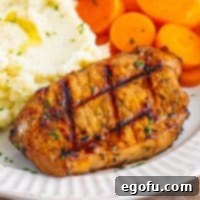 Close up looking at a Grilled Balsamic Pork Chop, showing its perfect grill marks and tender texture.