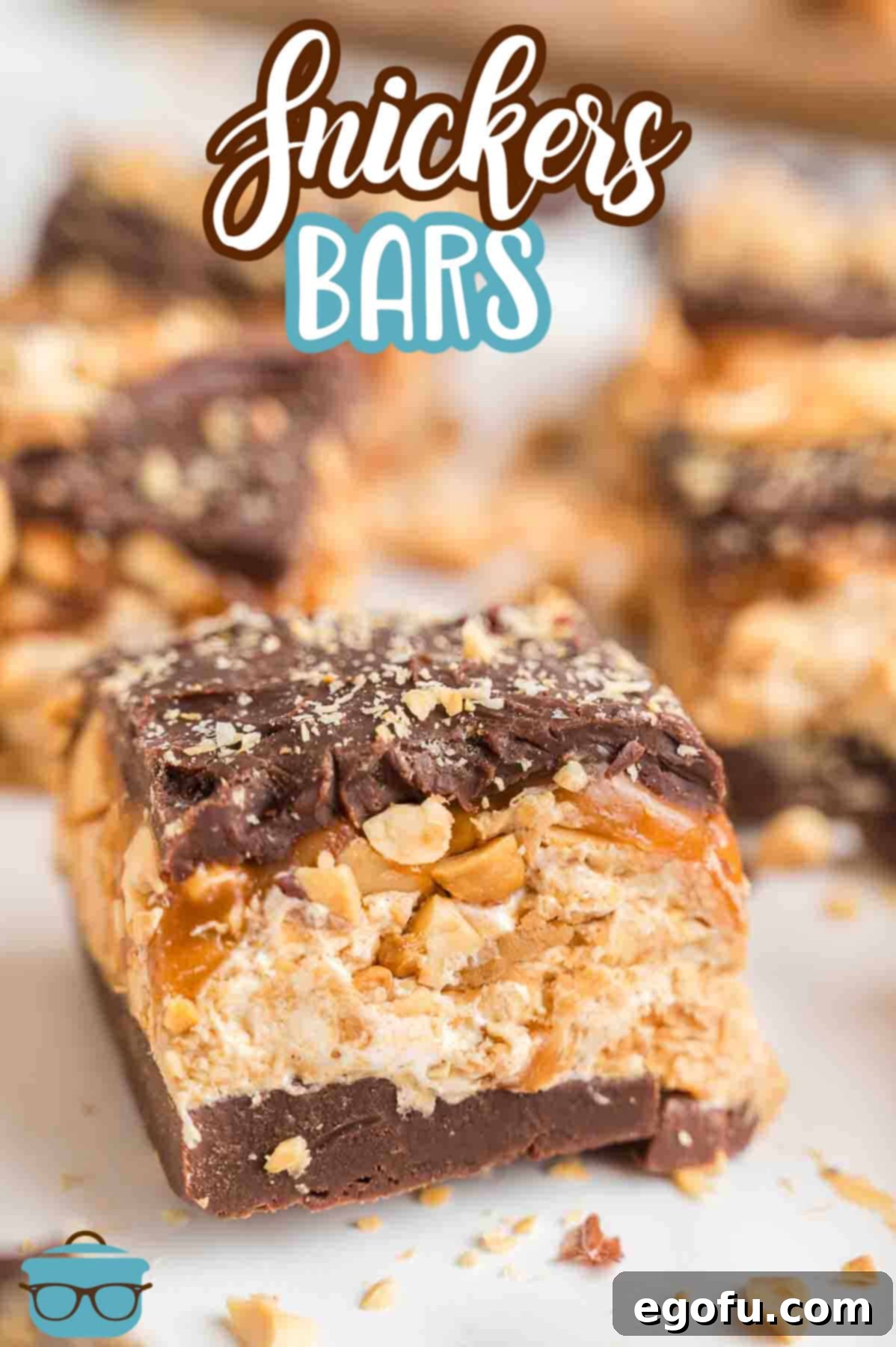 A perfectly stacked trio of homemade Snickers Bars, ready to be enjoyed.