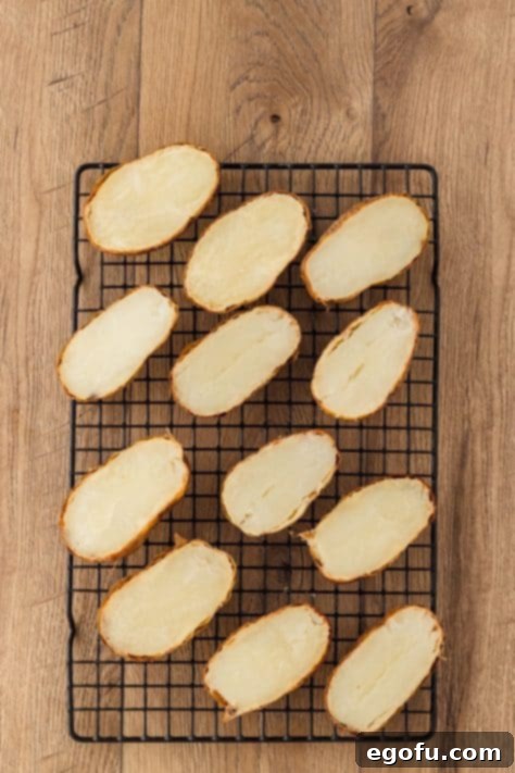 Cooked potatoes cut in half on a rack.
