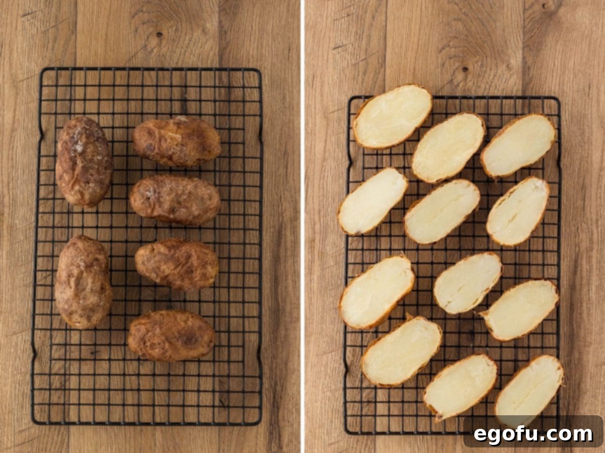 Cooked, golden-brown potatoes resting on a wire rack to cool, with some already sliced in half lengthwise.