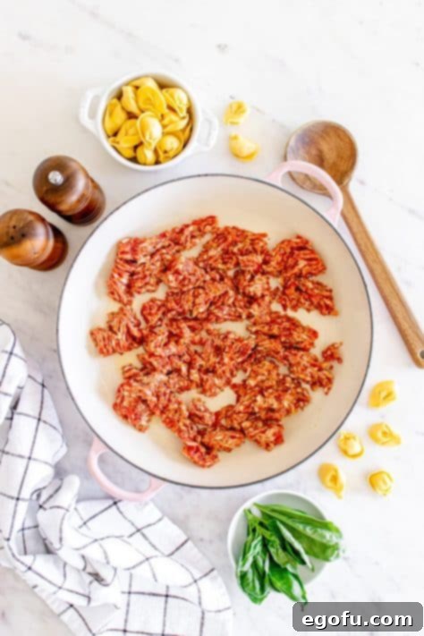 Creamy One-Pot Sausage Tortellini 9 A skillet with ground sausage browning.