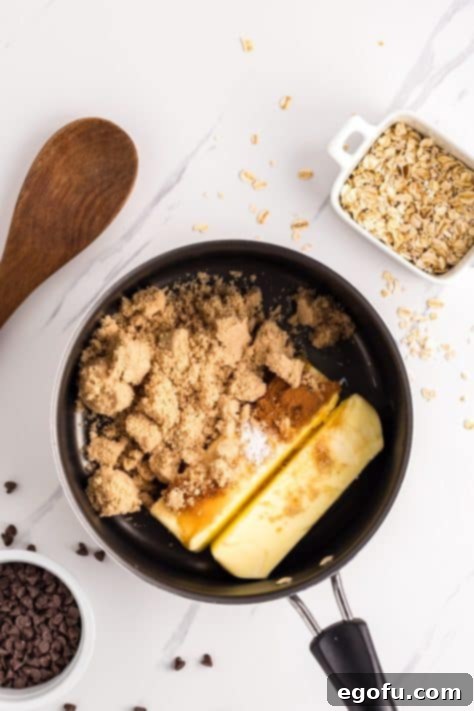 A saucepan with butter, brown sugar, vanilla, cinnamon, and salt, melting together into a rich liquid.