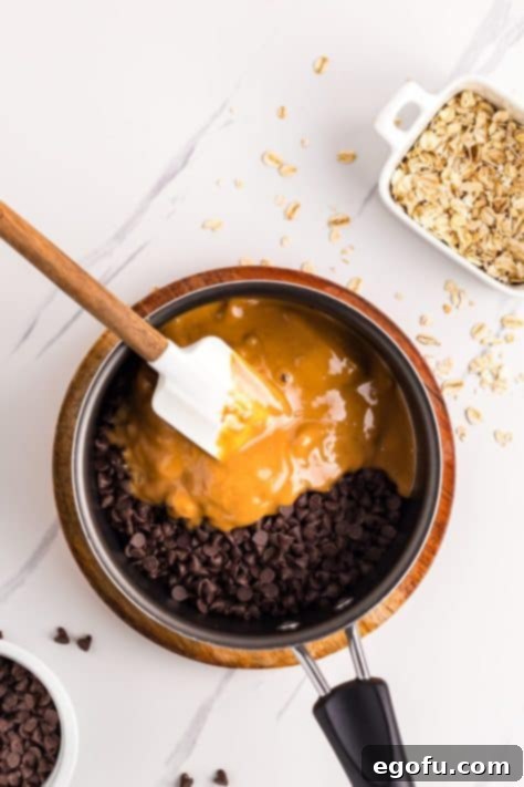 Chocolate and peanut butter in a saucepan, melting together into a smooth, glossy sauce.