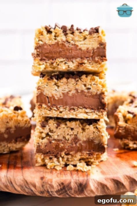 A stack of three perfectly portioned No Bake Chocolate Peanut Butter Oatmeal Bars, ready to be served.