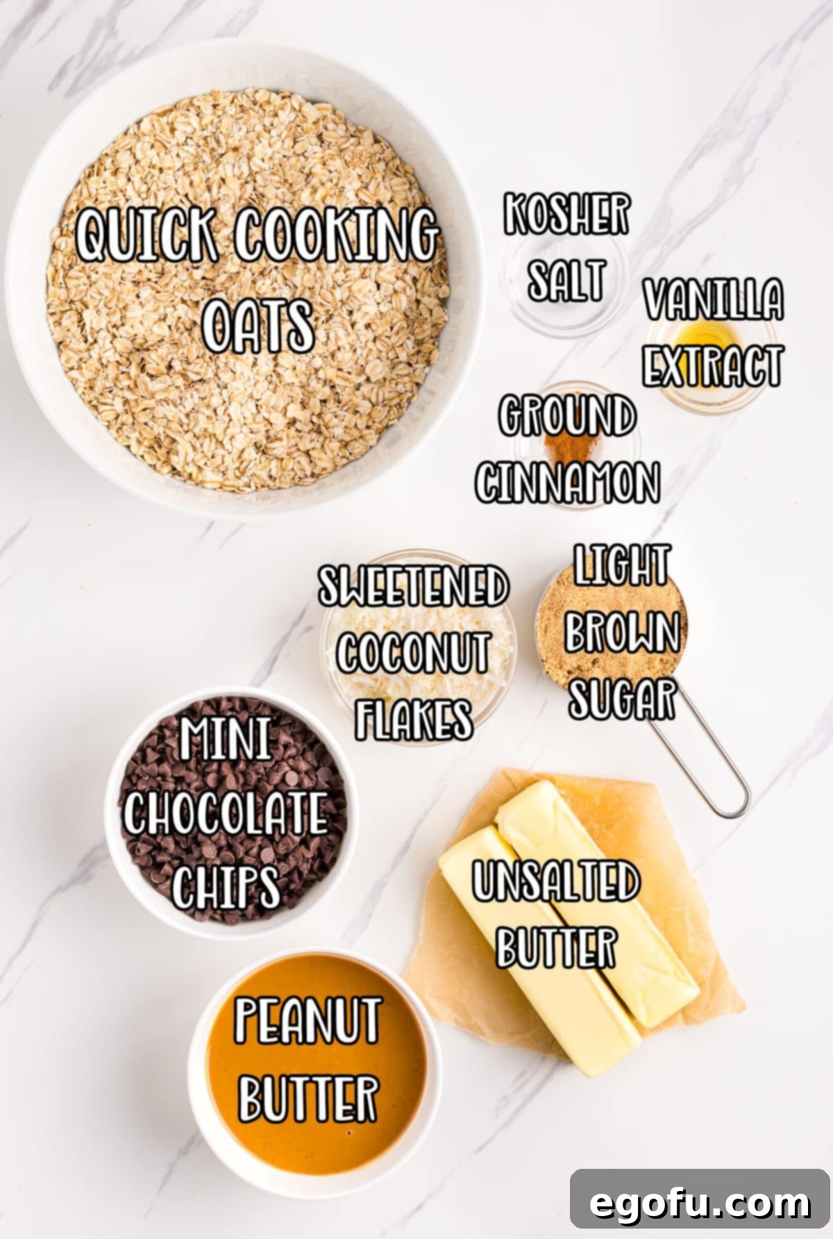 A vibrant flat lay of all the essential ingredients for No Bake Chocolate Peanut Butter Oatmeal Bars: quick cooking oats, butter, brown sugar, vanilla extract, ground cinnamon, kosher salt, creamy peanut butter, unsweetened coconut flakes, and mini chocolate chips.