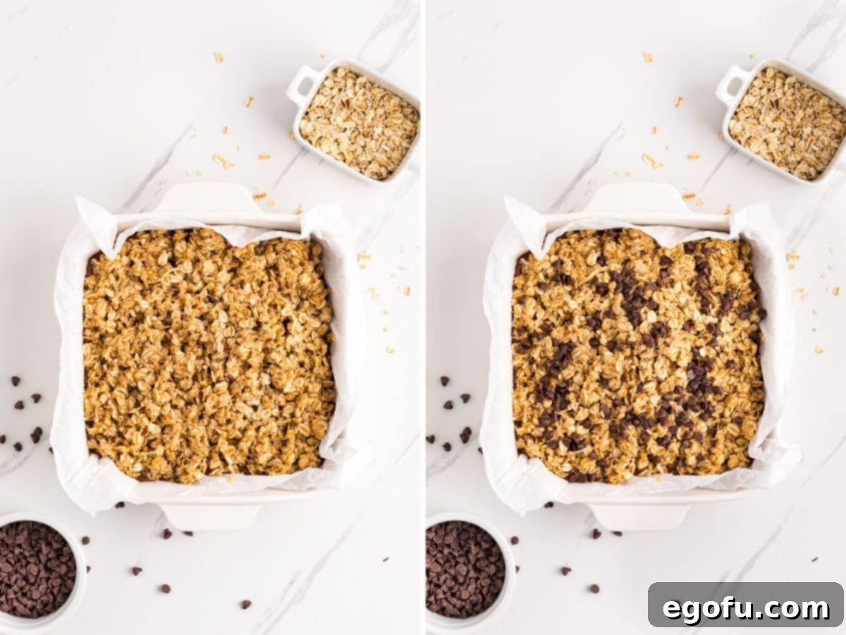 A baking dish filled with layered oatmeal bars, topped with a generous sprinkle of mini chocolate chips, ready for chilling.