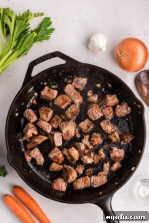 Seared chuck steak in a cast iron skillet.