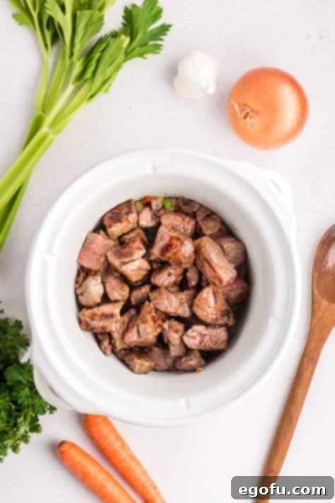 Veggies and seared steak in a Crockpot.