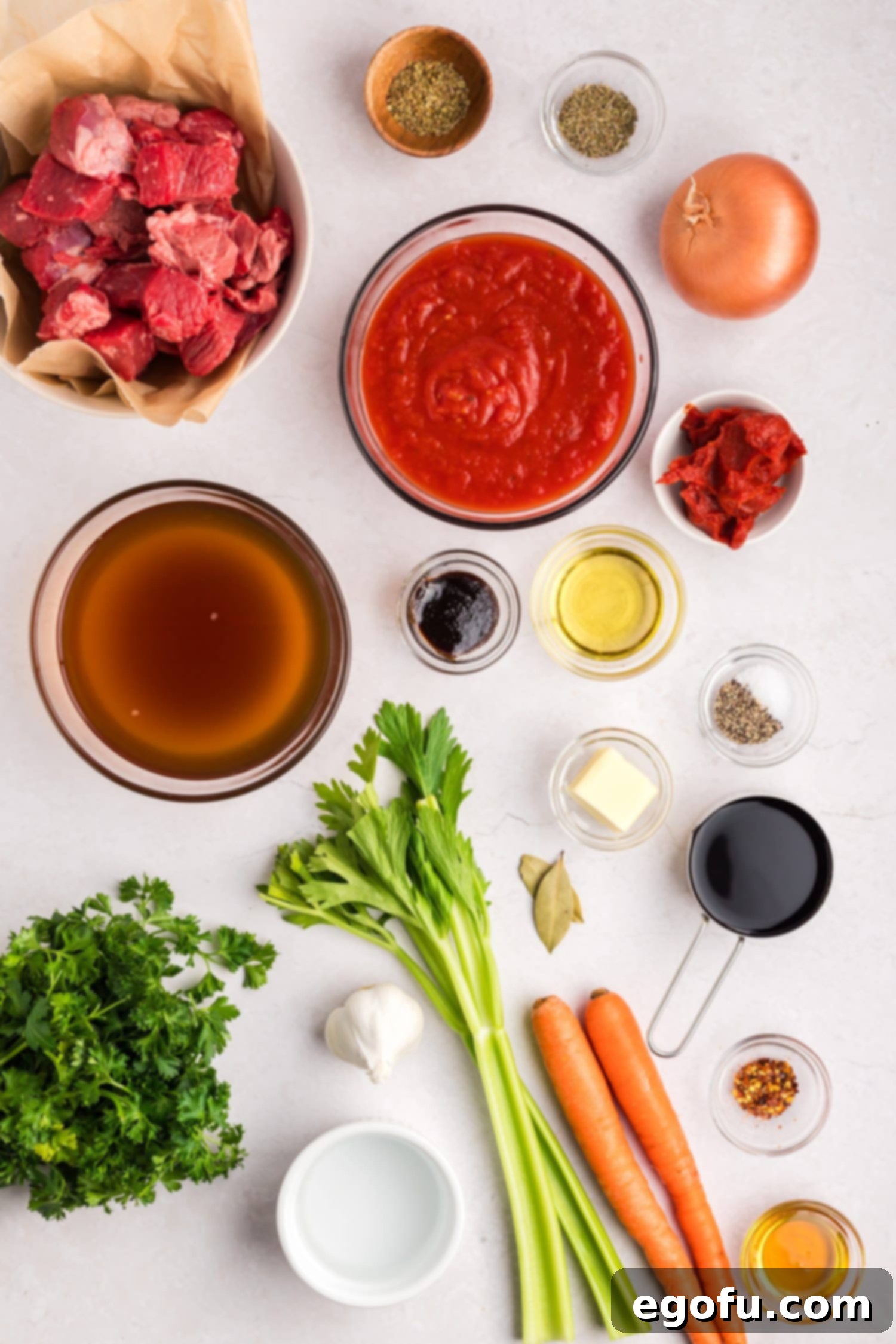 Olive oil, butter, yellow onion, carrots, celery, garlic cloves, black pepper, kosher salt, beef chuck steak, crushed tomatoes, beef stock, red wine, tomato paste, honey, parsley, better than bouillon beef base, oregano, thyme, red pepper flakes, bay leaves, and water. 