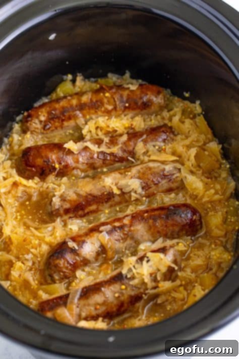 Hearty Slow Cooker Brats with Sauerkraut 7 Cooked Brats with sauerkraut in the Crockpot, ready to serve.
