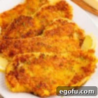 Crispy Parmesan Chicken Delight 8 Looking closely at a few pieces of Parmesan Crusted Chicken on a plate.