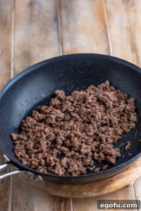 Cooked ground beef in a skillet, browned and ready for seasoning.