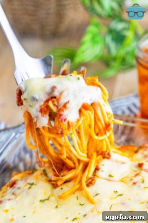 A serving of Baked Spaghetti for Two being lifted with a fork, ready to be enjoyed.