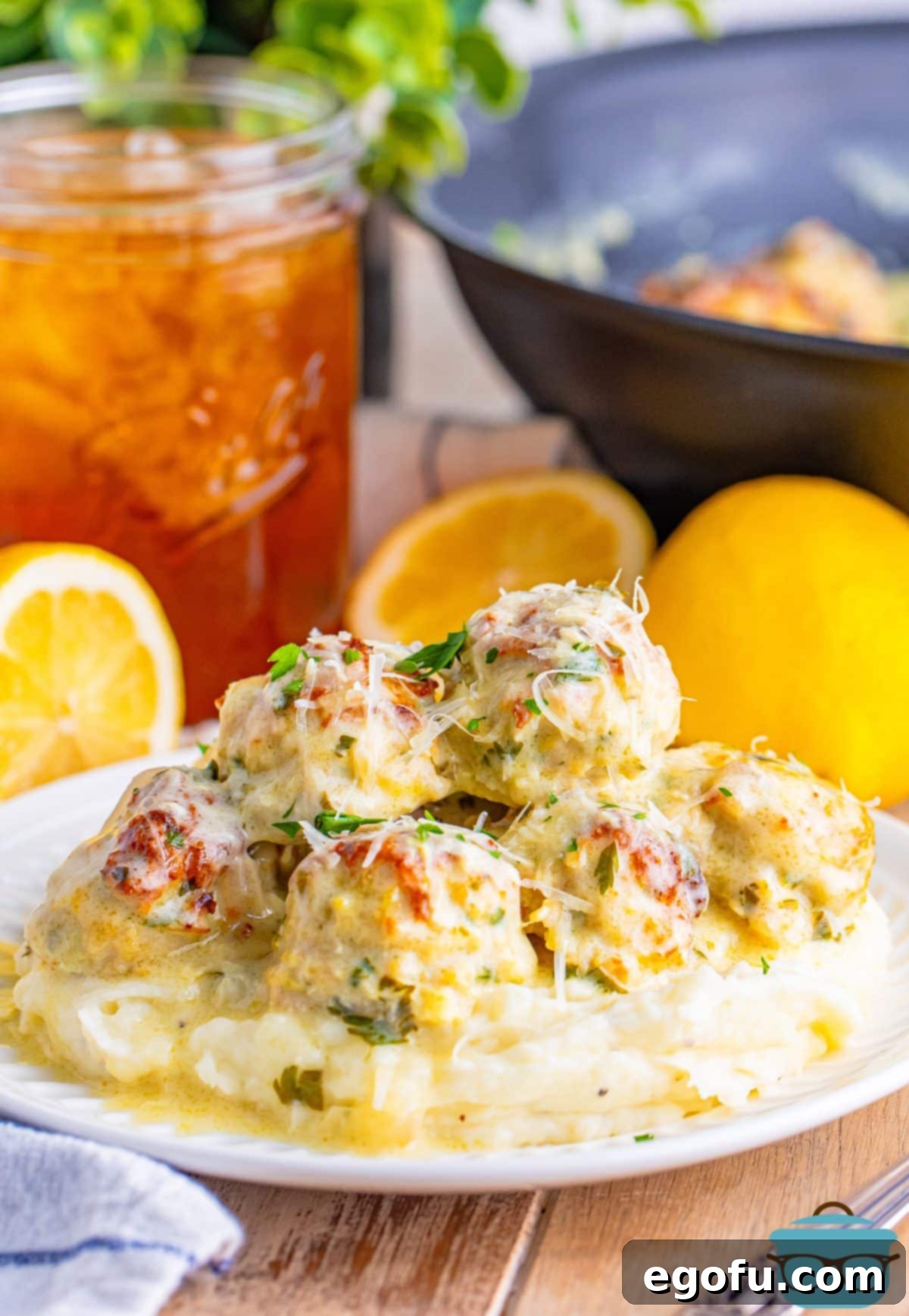 Zesty Piccata Chicken Bites 11 A plate with Chicken Piccata Meatballs lathered in tons of sauce.