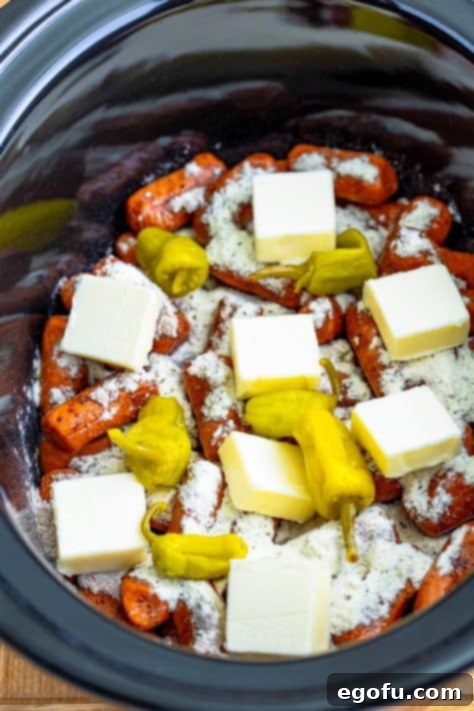 Irresistible Slow Cooker Mississippi Sausages 12 Lil smokies, pepperoncini juice, butter, peppers, au just gravy mix, and ranch seasoning in a Crockpot.