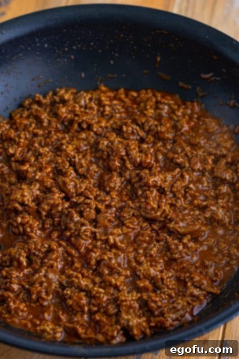 Taco seasoned ground beef simmering in a skillet, rich and aromatic.