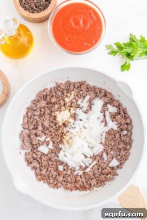 Ground beef and onion in a skillet.