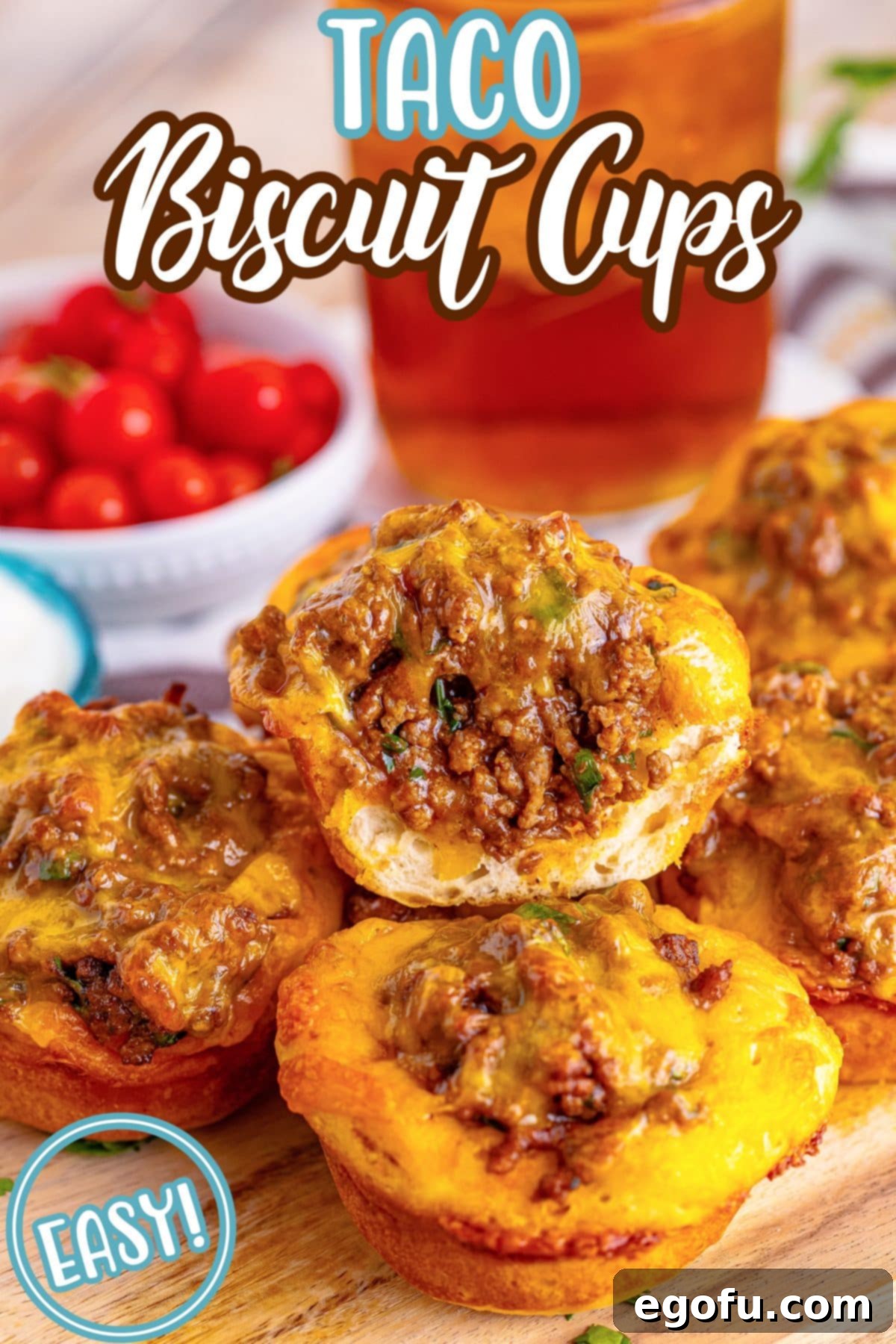 A small pile of golden brown Taco Biscuit Cups, one broken in half to show the cheesy, meaty filling.
