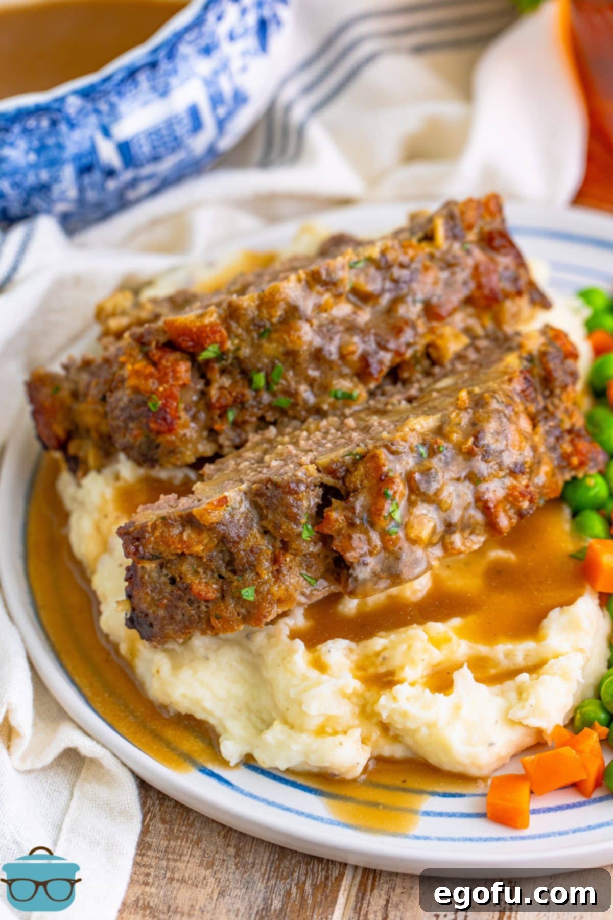 Several slices of golden brown Stove Top Stuffing Meatloaf served alongside fluffy mashed potatoes on a white dinner plate.